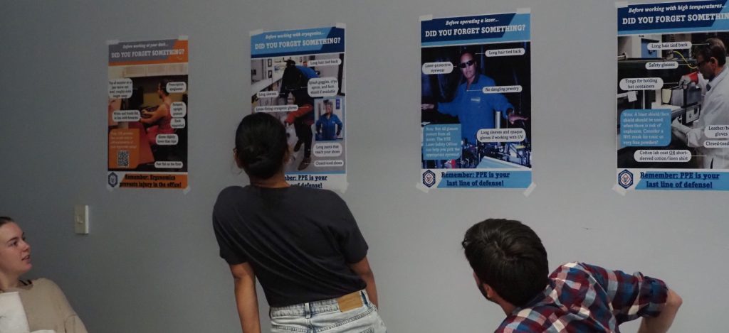 students viewing PPE posters