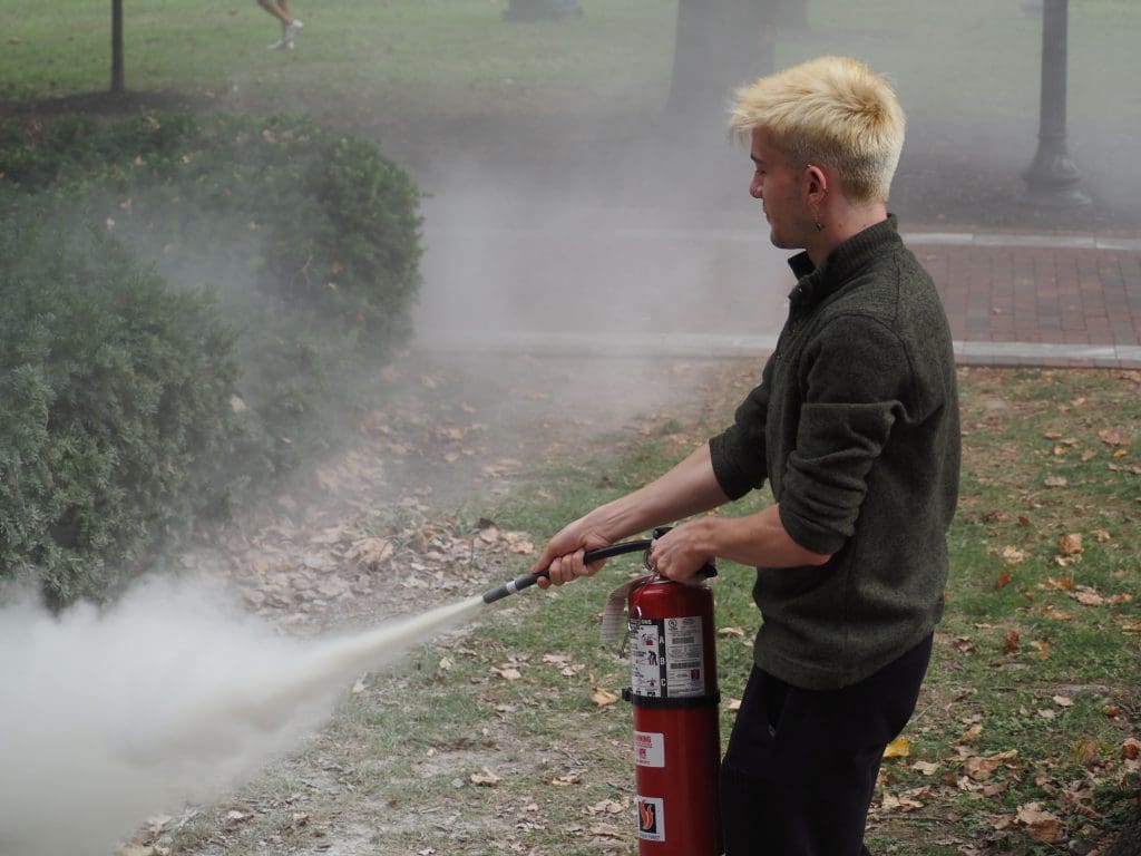 A student discharging a fire extinguisher