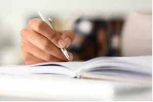 A student writes in a notebook.