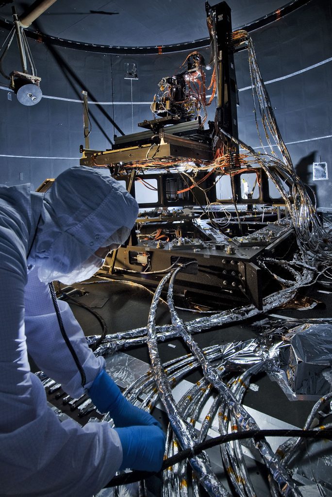 scientist working on integrated system module with photogrammatry in the background