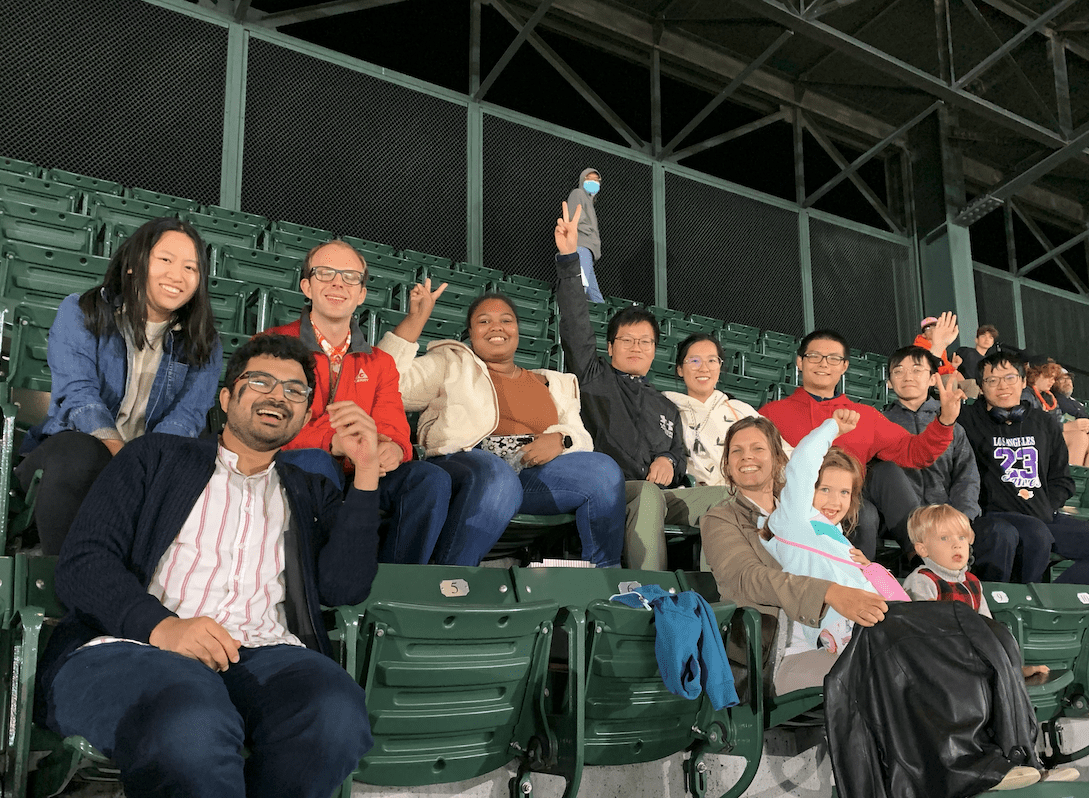 group of people sitting in green folding seats at Orioles stadium