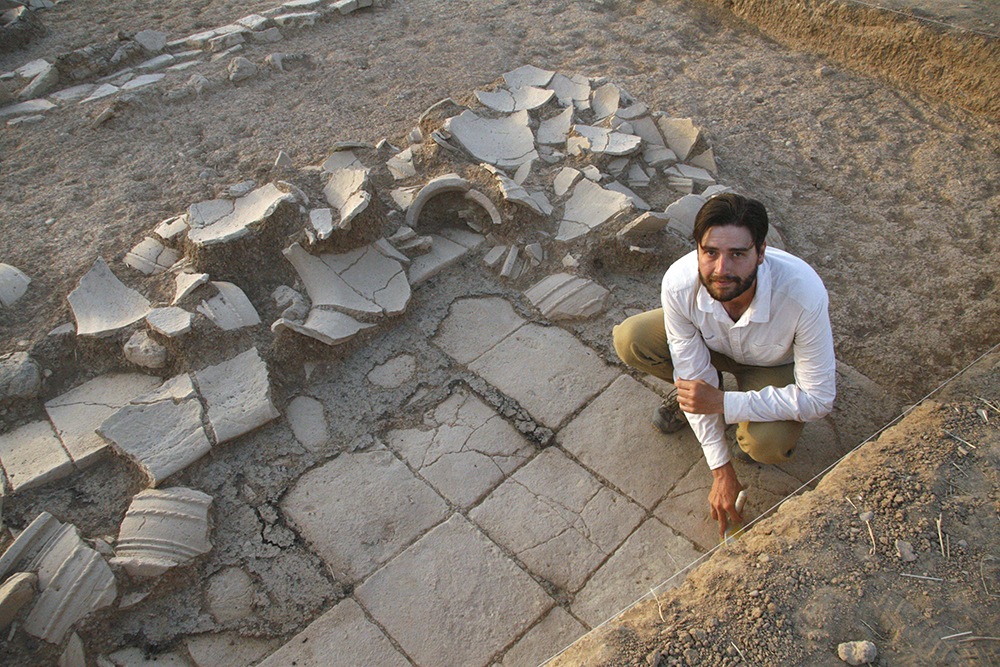 Man squatting among excavation debris