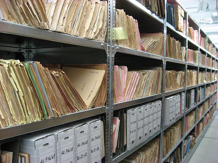 Folders and cartons of papers on metal shelves