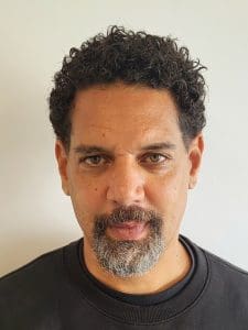 Headshot of Black man with goatee and black shirt