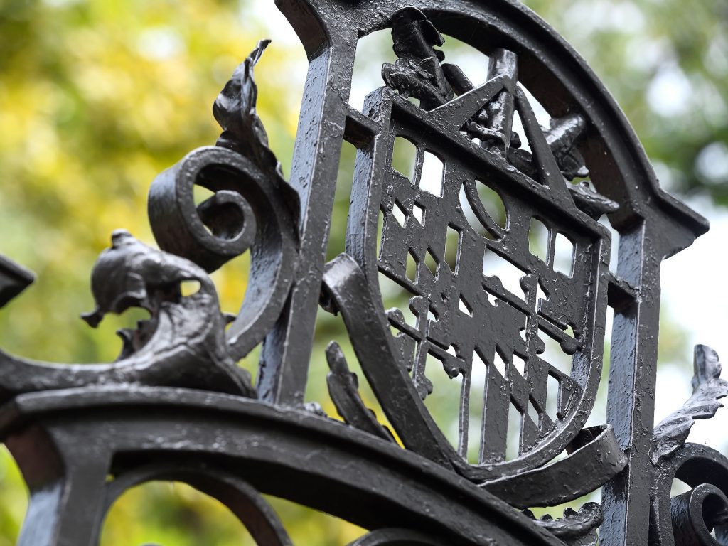 The JHU crest on a wrought iron fence